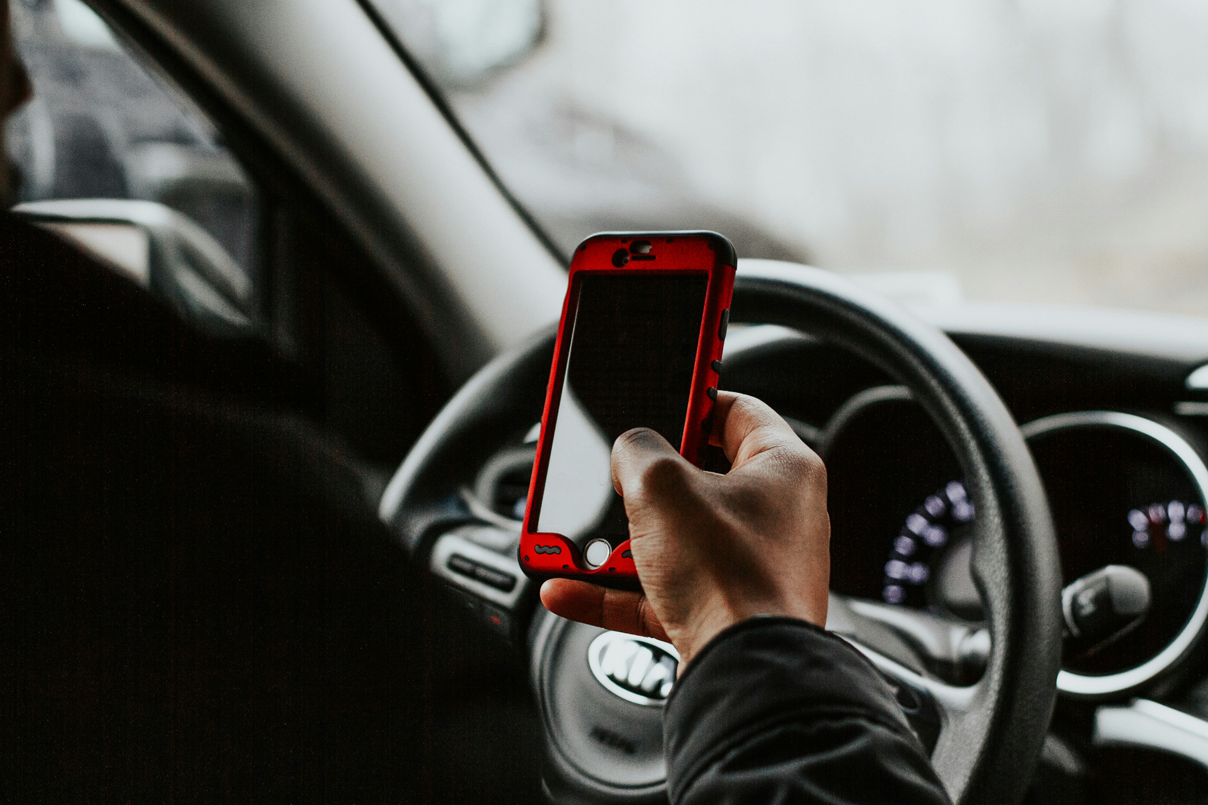Image of someone using their phone while driving 