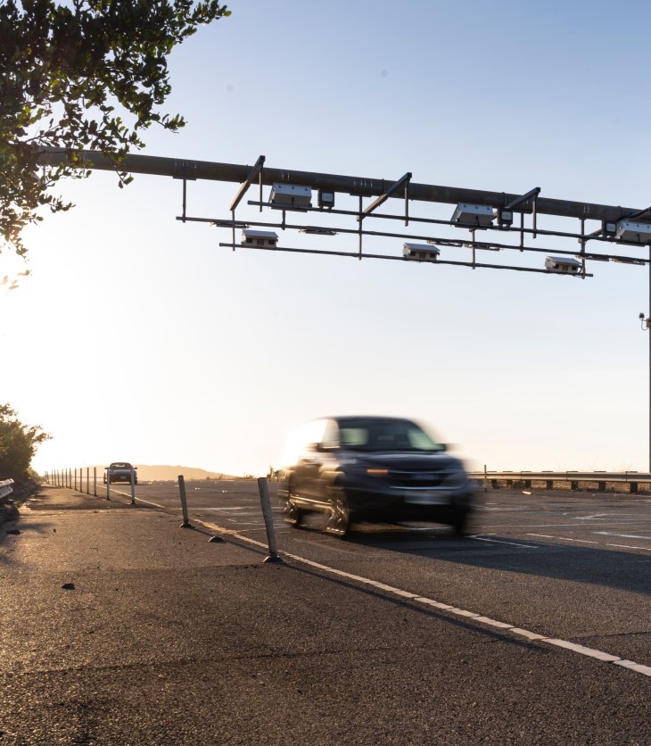 Image of a car driving through a toll point.