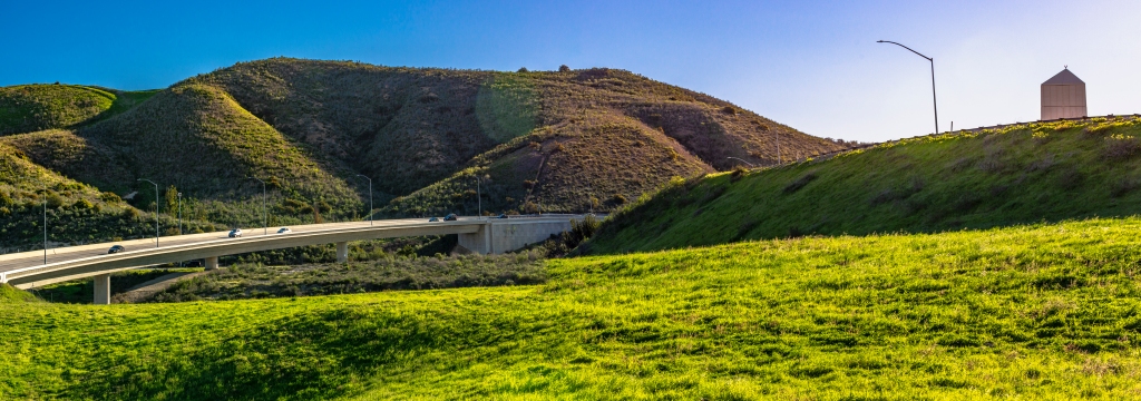 Photo of the 241 Toll Road connector to the 133 Toll Road with green rolling hills. 