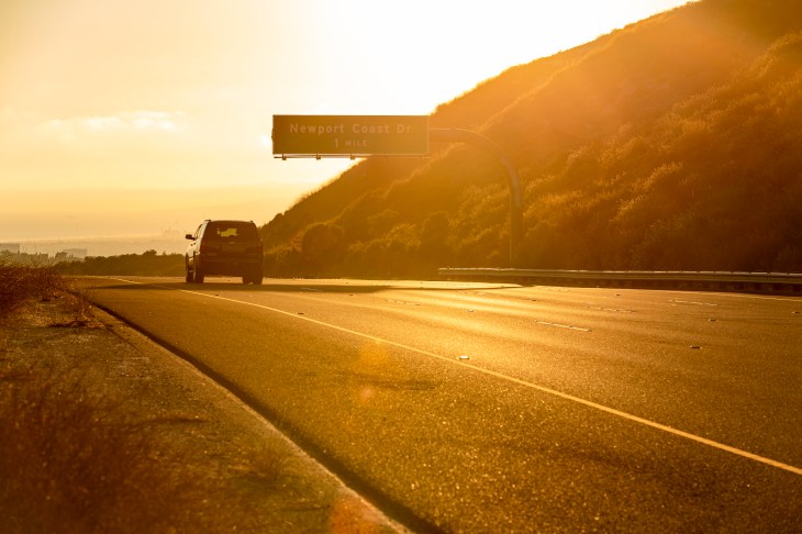 Photo of a car driving on the 73 toll road during golden hour