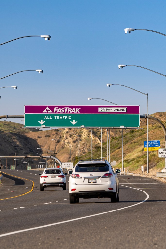 Photo of drivers on a road with signage overhead