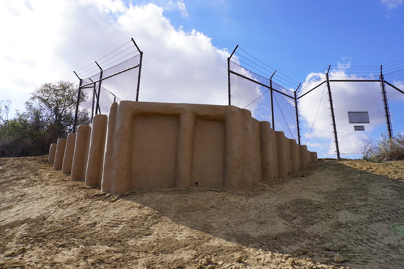 A view of a jump-out ramp and fence from the open space side.