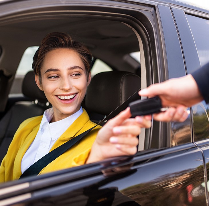 person receiving a car key while sitting in a car